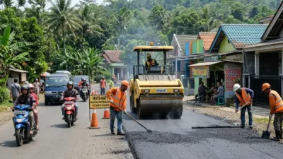 Jasa pengaspalan Cianjur melakukan pengaspalan jalan kabupaten menggunakan asphalt paver dan alat pemadat.